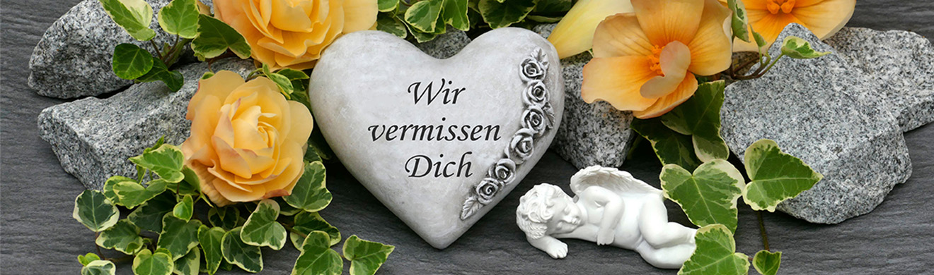 Herz mit Blumen und Engel auf einem Grab – Wir vermissen dich – symbolischer Grabschmuck für Erdbestattung in Schleiden. 
